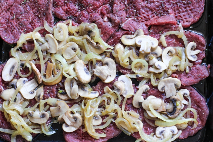 Выложите грибы и лук на мясо 
